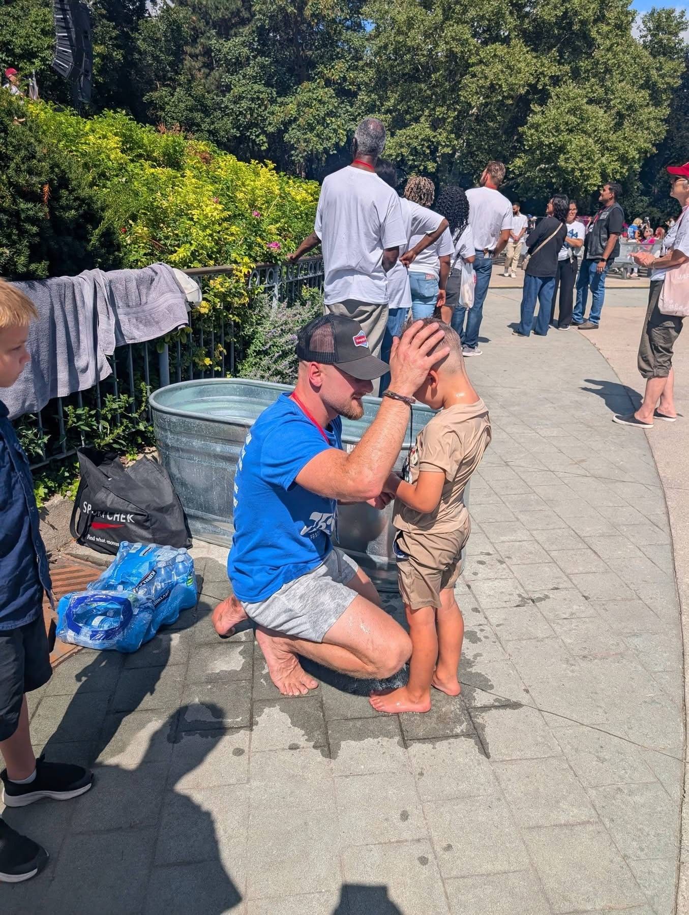 A boy prayed over after his baptism, with the line still waiting behind him